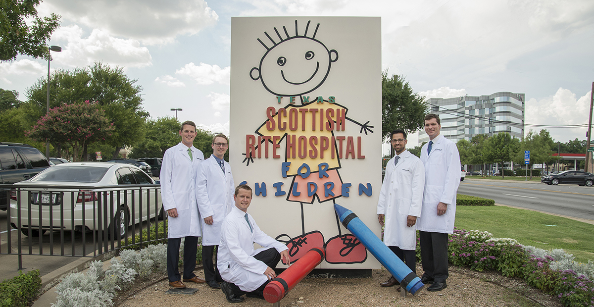 Fellows around hospital signage.