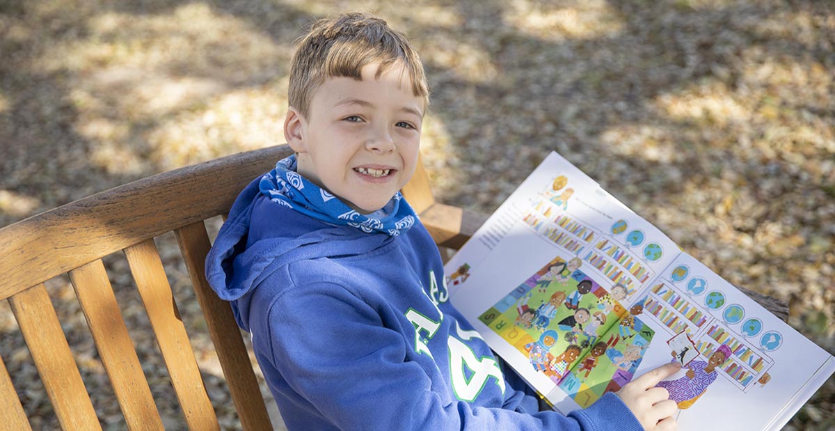 Miles on park bench with book