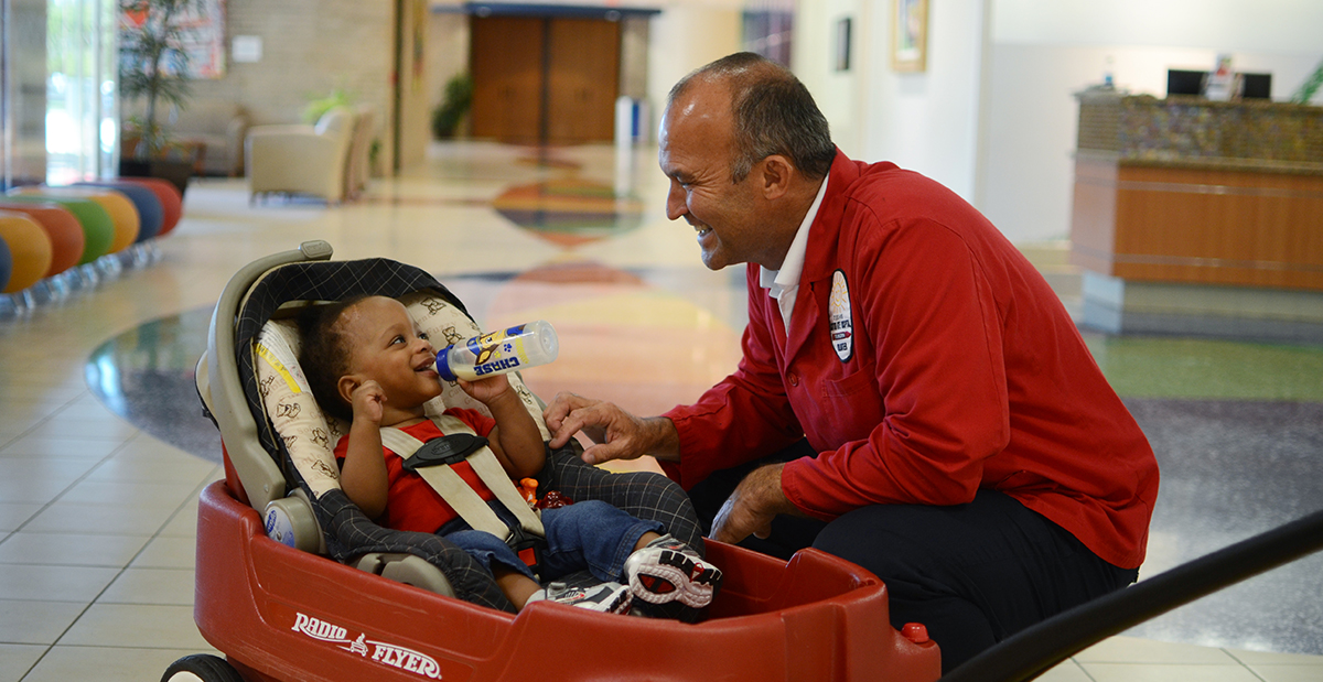 volunteer with patient in wagon in hall